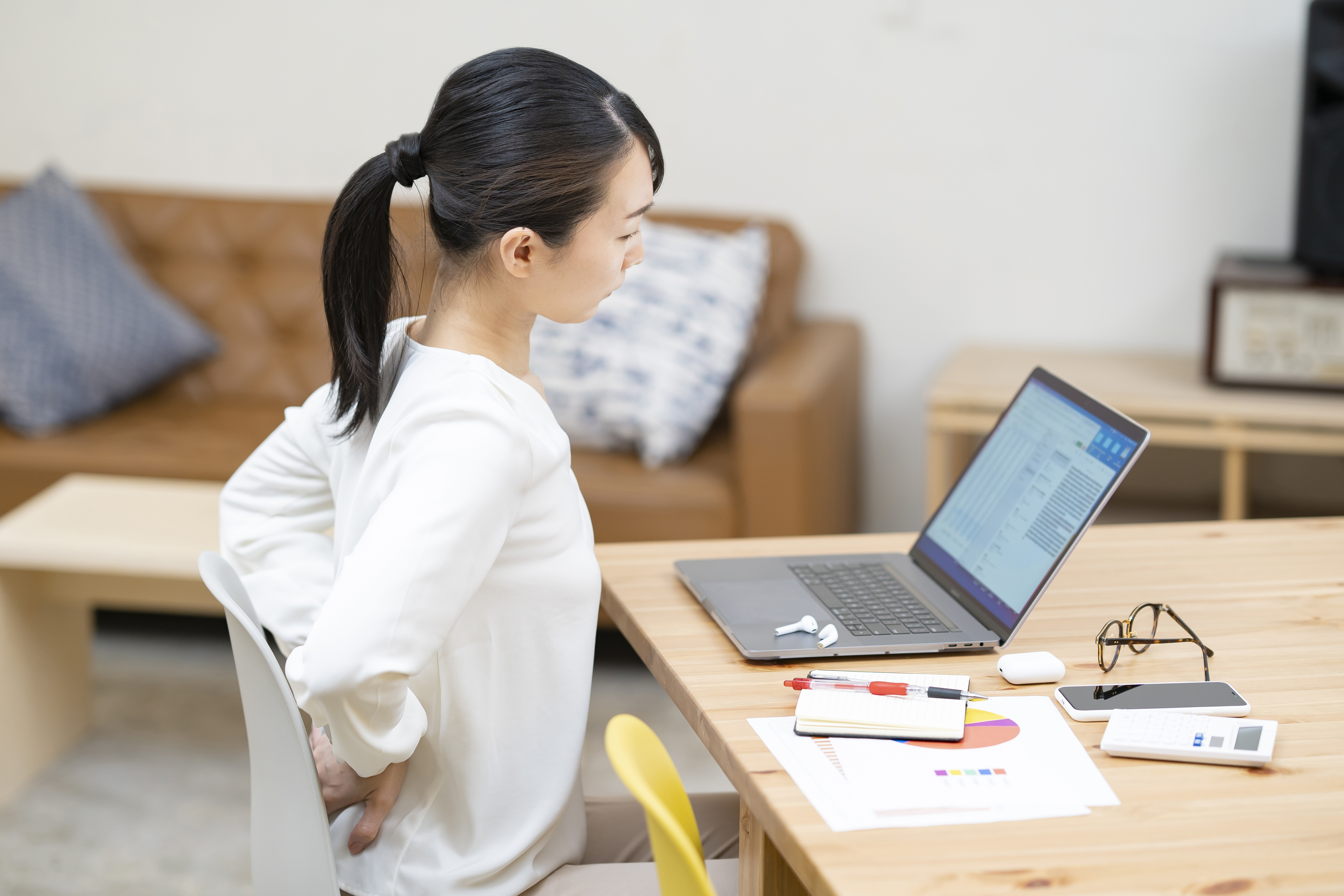 A woman suffering from back pain at work